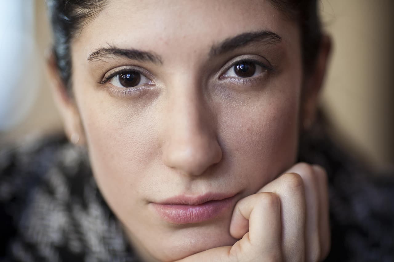 Woman resting her chin on her hand, thinking it over