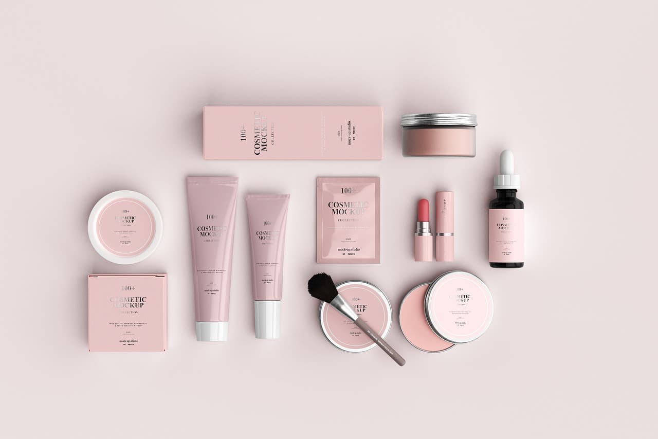 Skincare products laid out neatly on a pale pink surface